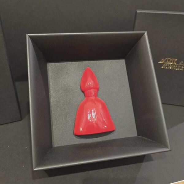 San Gennaro in ceramica rossa – Vista laterale Scultura di San Gennaro in ceramica rossa smaltata, raffigurazione stilizzata del patrono di Napoli, presentata in cornice nera moderna.