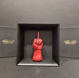 Mano in ceramica rossa con dito medio, trasformata in oggetto artistico di design ironico e dissacrante, perfetto per chi ama distinguersi.