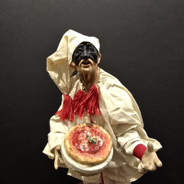 Pulcinella con pizza napoletana dettaglio volto e costume Dettaglio del volto e del costume in terracotta di Pulcinella con pizza napoletana.