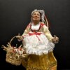 Dettaglio busto Bella 'Mbriana con grembiule bianco in pizzo e nastri rossi.