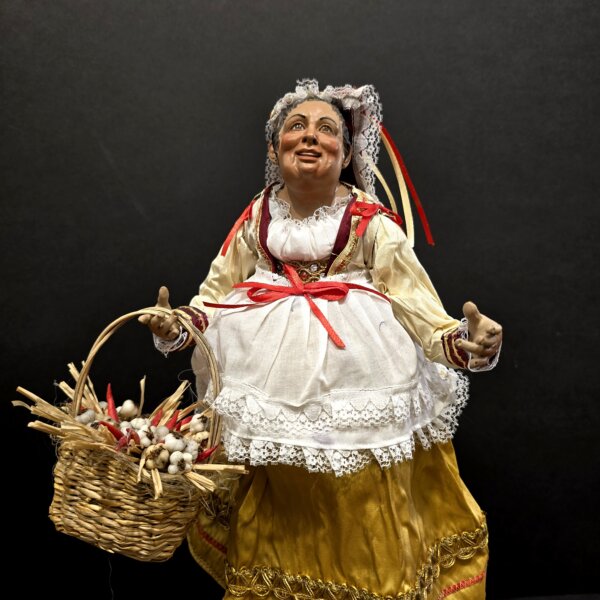 Dettaglio busto Bella 'Mbriana con grembiule bianco in pizzo e nastri rossi.