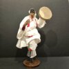 Statuetta artigianale di Pulcinella in terracotta, con abito bianco e tamburello, in posa danzante.