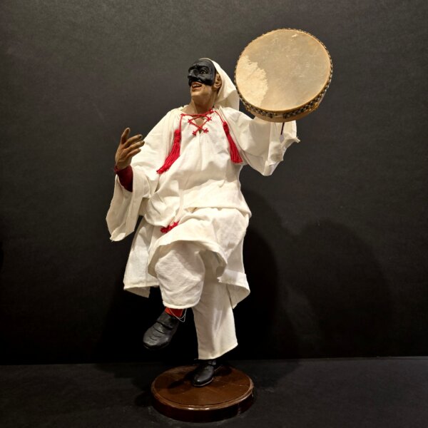 Scultura di Pulcinella artigianale in terracotta, vista laterale con tamburello e abito tradizionale bianco.