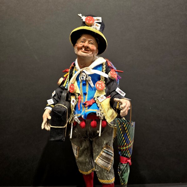 Dettaglio del busto dello Sciò Sciò Portafortuna con valigia e ombrello colorato, arricchito da simboli scaramantici.