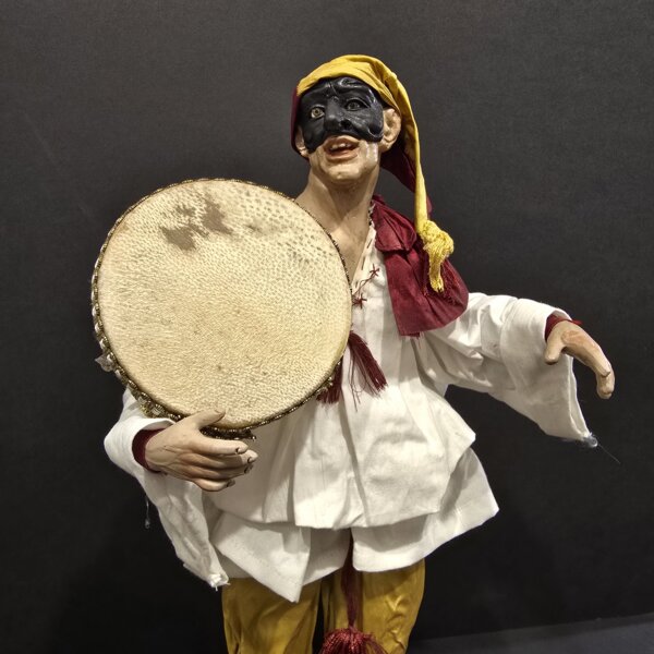 Pulcinella con tamburello e pantaloni gialli – dettaglio busto Dettaglio busto Pulcinella con tamburello e pantaloni gialli, lavorazione in terracotta. Vista laterale Pulcinella con tamburello e pantaloni gialli, scultura artigianale