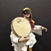 Pulcinella con tamburello e pantaloni gialli – vista laterale Vista laterale Pulcinella con tamburello e pantaloni gialli, scultura artigianale napoletana.