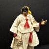 Pulcinella con cappello giallo e nappine rosse primo piano Dettaglio del volto e costume di Pulcinella con cappello giallo e nappine rosse.