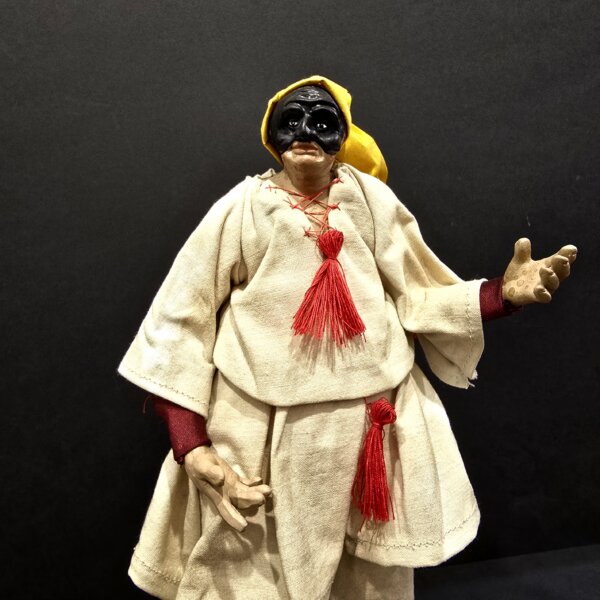 Pulcinella con cappello giallo e nappine rosse primo piano Dettaglio del volto e costume di Pulcinella con cappello giallo e nappine rosse.