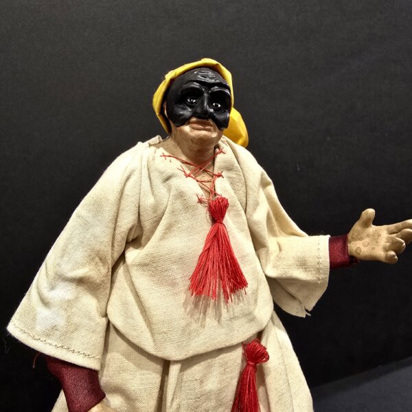 Pulcinella con cappello giallo e nappine rosse laterale Vista laterale della statua in terracotta di Pulcinella con cappello giallo e nappine rosse.