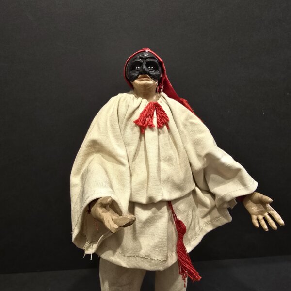 Pulcinella con berretto rosso – dettaglio busto Dettaglio del busto di Pulcinella con maschera nera e berretto rosso in terracotta artigianale.