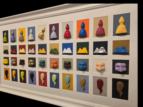 Vista angolata dell’opera “I 40 Bassorilievi”, mostra i volumi e i colori vivaci dei bassorilievi artigianali.