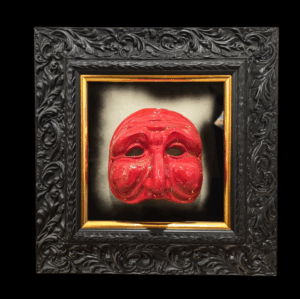 ista Frontale Opera Pulcinella Rosso in Cornice Barocca Immagine frontale dell'opera che mostra il contrasto tra la maschera rossa lucida, il fondo specchiato scuro e la ricca cornice nera con filetto oro.
