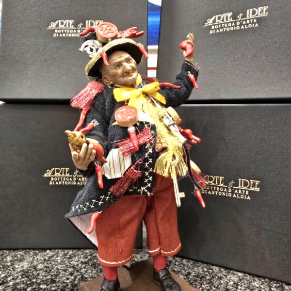 Dettaglio del busto dello Scio'Scio' con cornetti rossi, numeri della smorfia napoletana e ricami dorati sulla giacca nera.