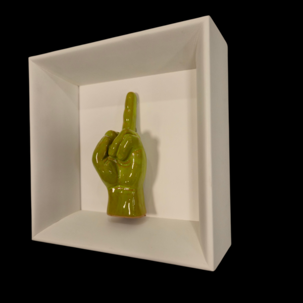 dettaglio-dito-pop-design-napoletano Inquadratura laterale destra della teca 18x18 cm con il dito medio in ceramica verdino lucido.
