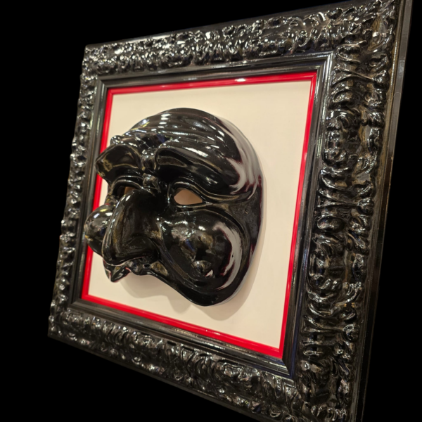 cornice-nera-lucida-pulcinella-dettaglio Dettaglio della cornice in legno nero lucido e della finitura della maschera di Pulcinella.