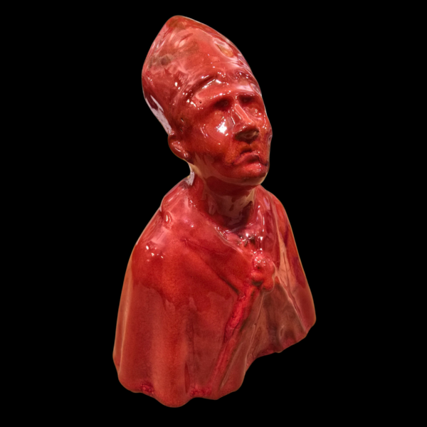 Vista laterale della scultura di San Gennaro in ceramica rossa con design stilizzato.