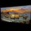 Visione angolata da destra del quadro panoramico che esalta la vividezza dei colori caldi del cielo serale e i profondi riflessi del tramonto sul mare del golfo.